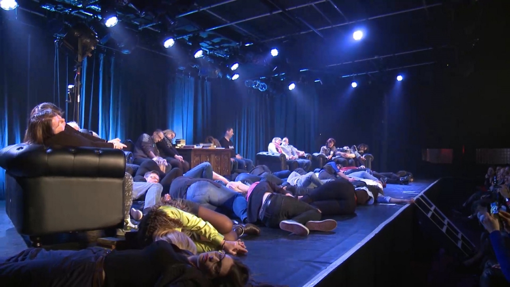 Hervé Barbereau hypnotiseur Un groupe de personnes hypnotisées sur scène dans une ambiance de spectacle.