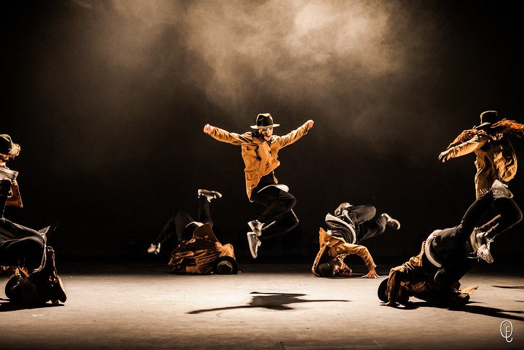 The Rookies Danseurs en pleine performance, sautant et exécutant des mouvements dynamiques sur scène.