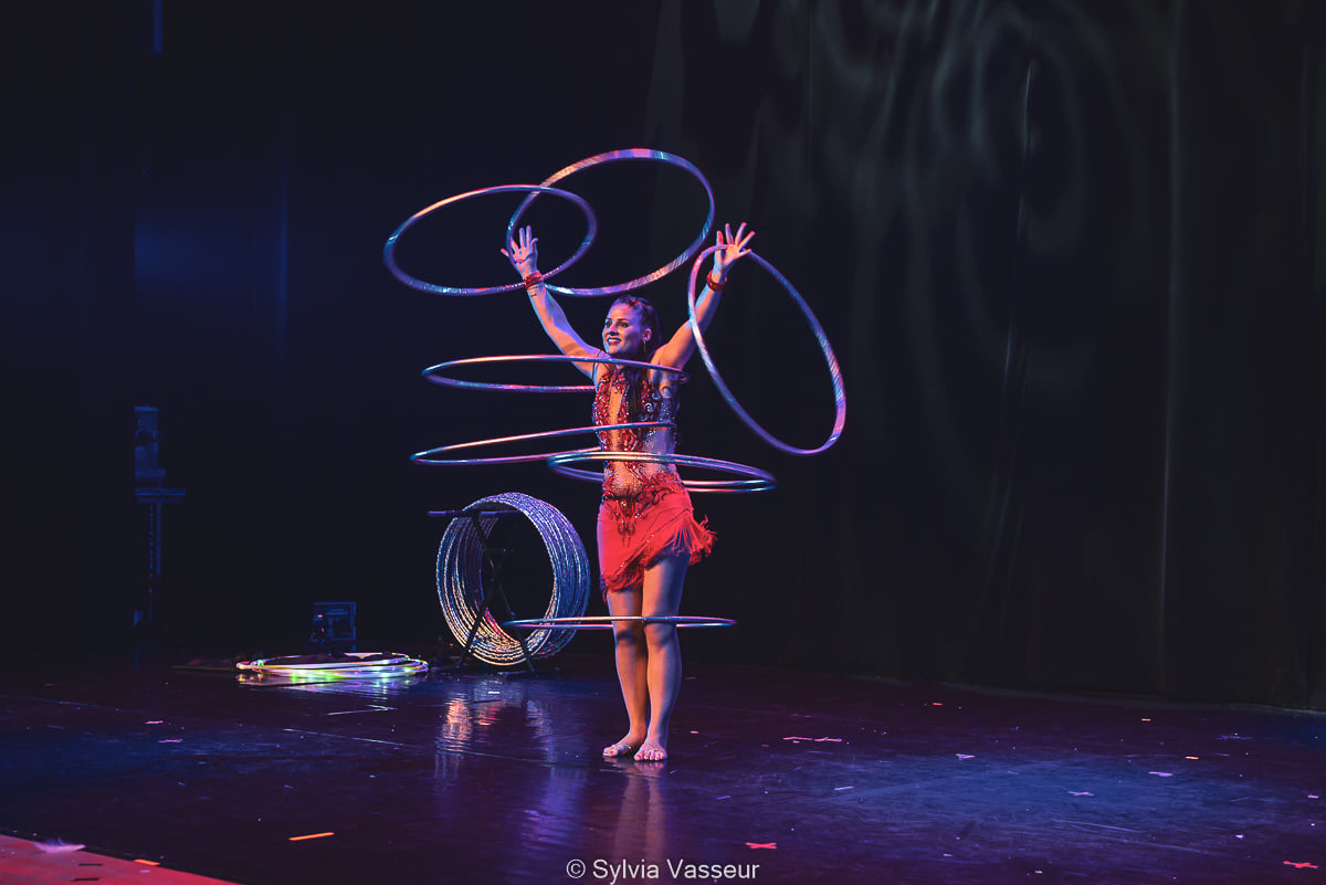 Stellina Kenjys - Hula hoop performer Une femme réalise une performance de hula-hoop sur scène.